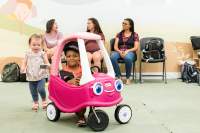 Moms talking in background behind toy car